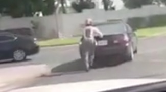 Dubai Policeman heroically pushes a stalled car down a highway